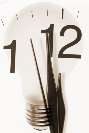 Composite of Clock Hands and Light Bulbの写真素材
