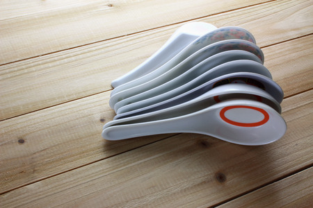 Stack of Chinese Soup Spoons on Wooden Backgroundの写真素材