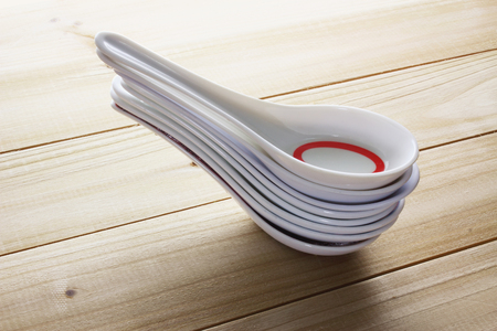 Stack of Chinese Soup Spoons on Wooden Backgroundの写真素材