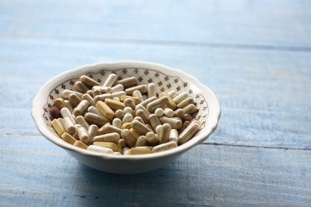 Bowl of Pills on Wooden Backgroundの写真素材