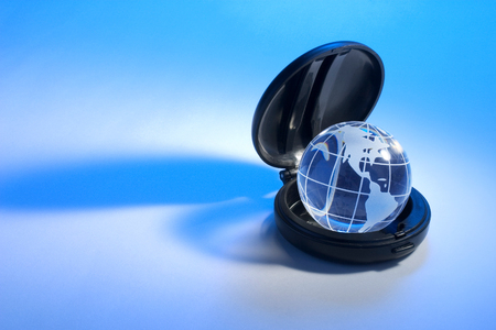 Globe in Compact Case on Blue Backgroundの写真素材