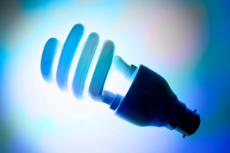 Compact Fluorescent Light Bulb on Blue Backgroundの写真素材