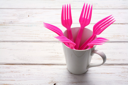 Plastic Forks and Cup on Wooden Backgroundの写真素材