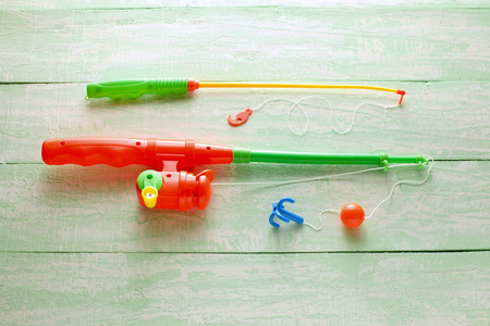 Toy Fishing Rods on Wooden Background