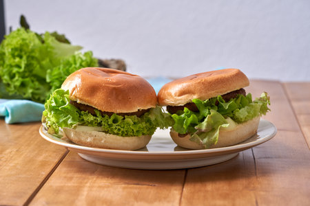 Delicious hamburger with green salad on wooden table.の写真素材