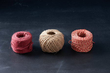 A tangle of multi-colored threads on a dark background.の写真素材