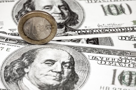 euro and dollar currencyEuro coins on the background of dollar banknotesの写真素材