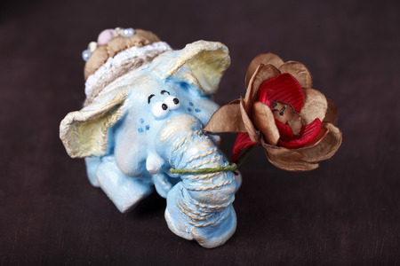 blue statuette of an elephant with a flower in the trunkの写真素材
