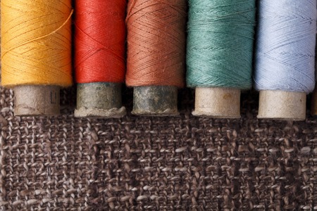 bobbins with colorful threads On a beautiful brown background