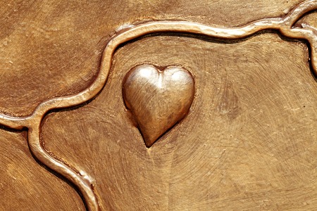 a beautiful heart of metal painted in gold paintの写真素材