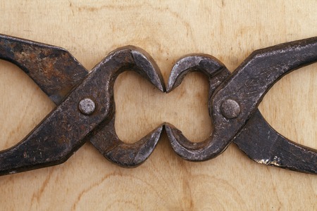 a old vintage tongs tool on a wooden background