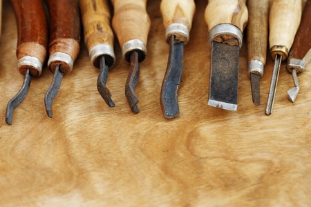 Vintage tools of woodcarving closeup on wooden background