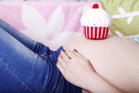 pregnant young girl belly close-up, in anticipation of a new lifeの写真素材