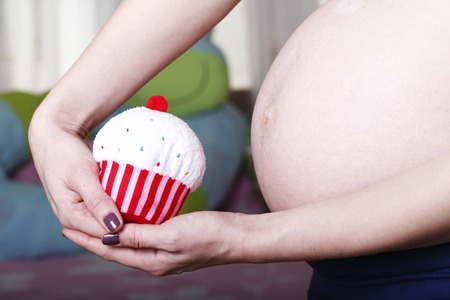 pregnant young girl belly close-up, in anticipation of a new lifeの写真素材