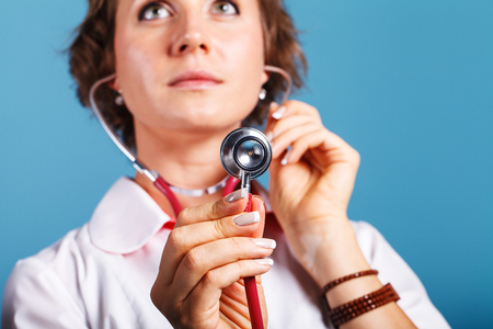 Portrait of a young woman doctor with stethoscope in studioの写真素材