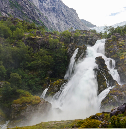 Panoramic view to Kleivafossen waterfall on Briksdalselva river, Briksdalsbreen glacier, Norwayの写真素材