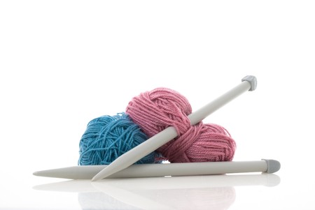 Balls of blue and pink  knitting wool or yarn, with silver knitting needles.