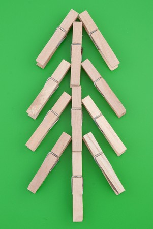 Pine tree made of wooden clothes pegs on a green background.の写真素材