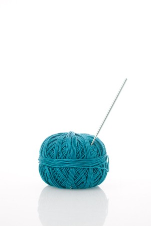 Blue spool and needle on a white background.