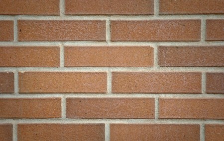 Modern red brick wall with shadow in the corners.