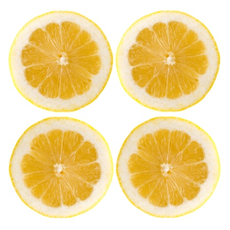 Four fresh lemon halves on white background.の写真素材