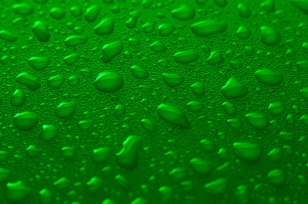 Green water drops background with yellow reflections.の写真素材