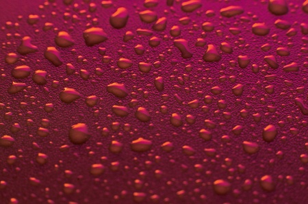 Pink water drops background with yellow reflections.の写真素材