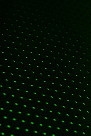 Black plastic mesh texture backlit with green light.