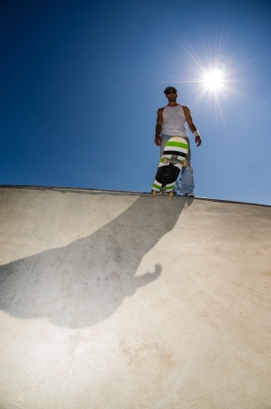 Skateboarder in a concrete pool at skatepark on a sunny day.の写真素材