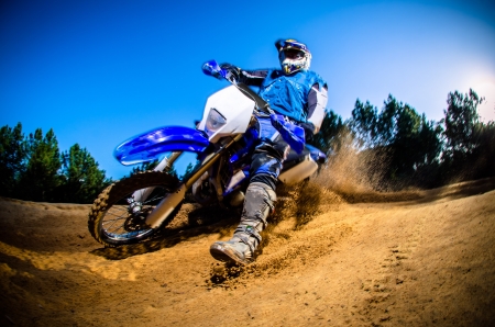 Enduro bike rider on action. Turn on sand terrain. Enduro bike rider on action. Turn on sand terrain.