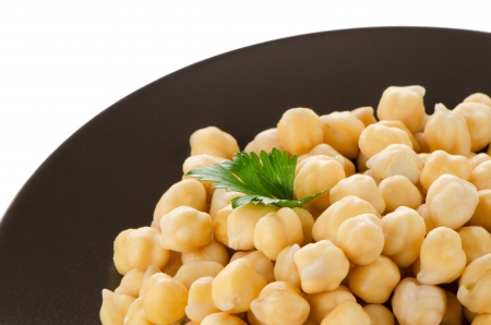 Chickpeas in a brown plate, isolated over white background.の写真素材