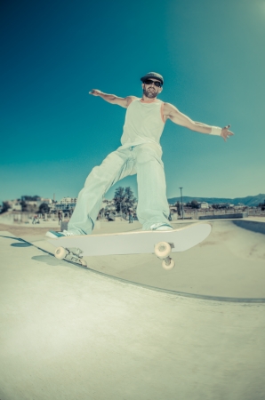 Skateboarder in a concrete pool at skatepark on a sunny day.の写真素材
