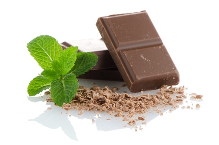 Closeup detail of chocolate parts and mint leaves on white background.の写真素材