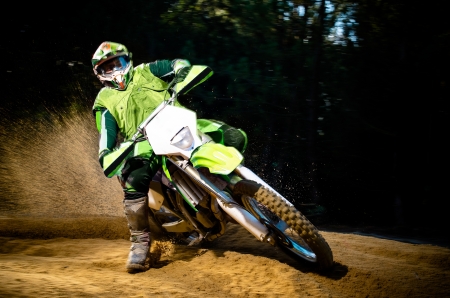 Enduro bike rider on action. Turn on sand terrain. Enduro bike rider on action. Turn on sand terrain.