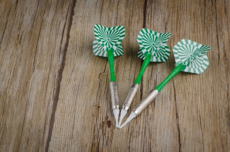 Three arrows darts on old wooden table.の写真素材