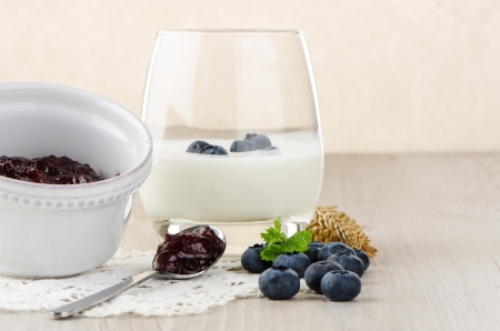 Yogurt with fresh blueberries on a wooden table set.の写真素材