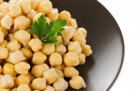 Chickpeas in a brown plate, isolated over white background.の写真素材