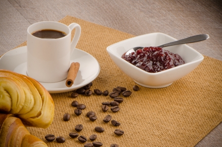 Cup of black coffee and croissant over sackcloth baclground.の写真素材