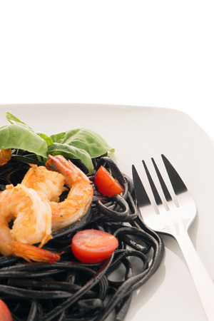 Black spaghetti with shrimps isolated on whiteの写真素材