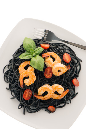 Black spaghetti with shrimps isolated on whiteの写真素材