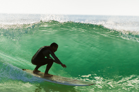 Long boarder surfing the waves at sunset in Portugal.の写真素材