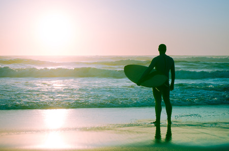 Surfer watching the waves at sunset in Portugal.の写真素材