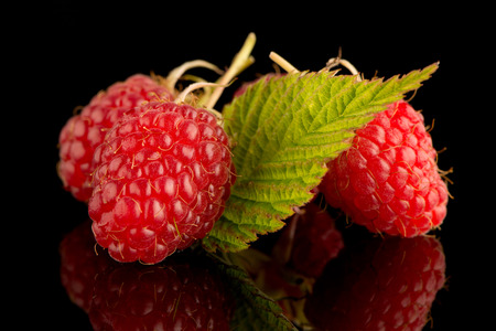 Fresh raspberries on black reflective background.の写真素材