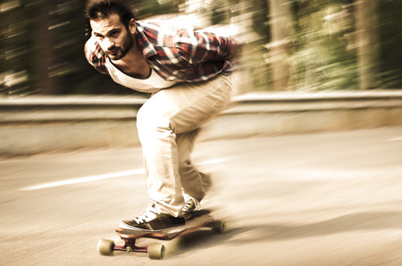 Downhill skateboarder in action on a asphalt road.