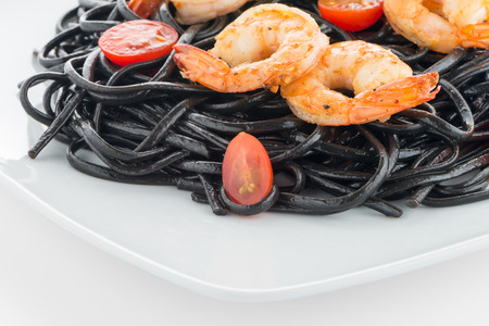Black spaghetti with shrimps isolated on whiteの写真素材
