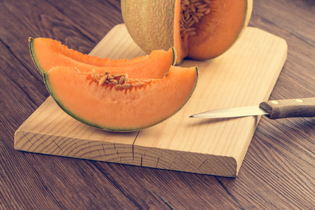 Juicy honeydew melon on a wooden table background.の写真素材