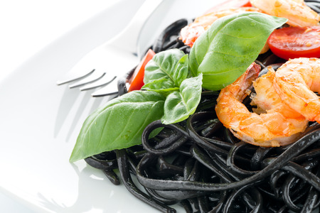 Black spaghetti with shrimps isolated on whiteの写真素材