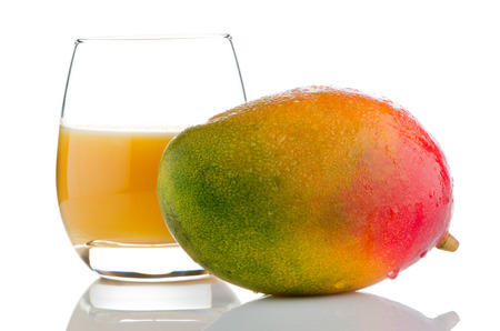 Fresh mango juice and mango fruit on white reflective background.の写真素材