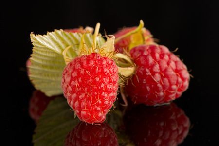 Fresh raspberries on black reflective background.の写真素材