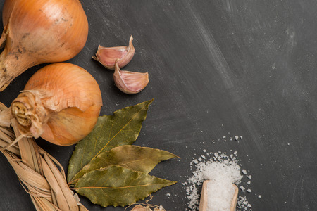 Onions and garlic  over black chalkboard background.の写真素材